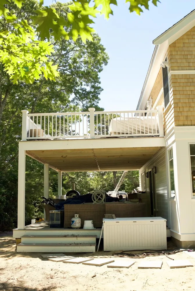 Second floor deck with white railings over a covered patio