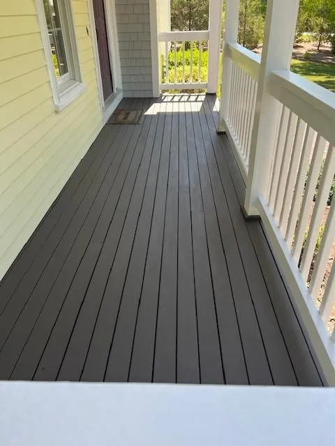 Covered front porch with dark composite decking and white columns